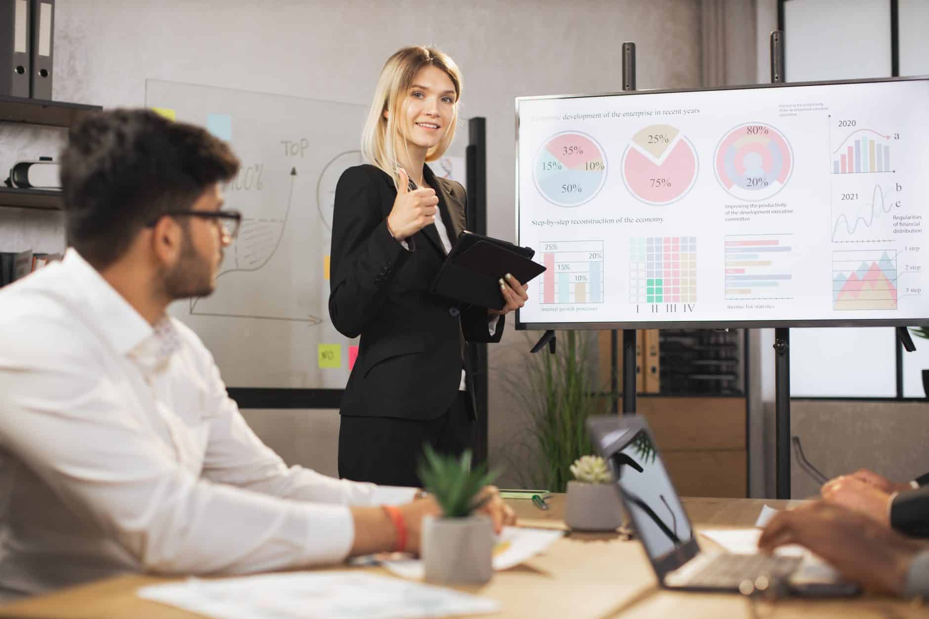 beautiful confident businesswoman lady, showing her financial ad sales report on big digital screen